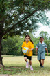 © Austockphoto - Two Australian primary school girls doing sports outside running with ball