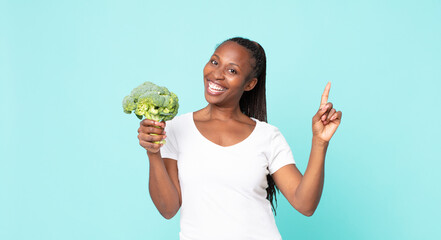 Wall Mural - black african american adult woman holding a broccoli