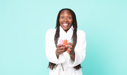 Wall Mural - black african american adult woman wearing bathrobe and holding cosmetic products