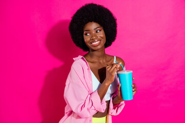 Poster - Photo of charming pretty dark skin lady wear casual shirt drinking soda looking empty space smiling isolated pink color background