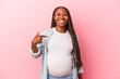 Young african american pregnant woman isolated on pink background person pointing by hand to a shirt copy space, proud and confident