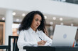 © yurolaitsalbert - young woman works sitting at a table in a food court .