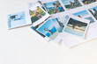 © OleJohny - Printed and cut-out photos on a white background. There are a lot of polaroid photos on the table.