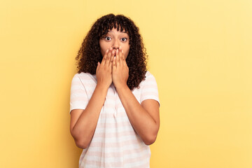 Poster - Young mixed race woman isolated on yellow background shocked, covering mouth with hands, anxious to discover something new.