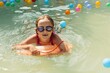 A girl playing in garden swimming pool. Portret outside in water. 