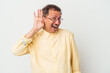 © Asier - Middle aged indian man isolated on white background trying to listening a gossip.