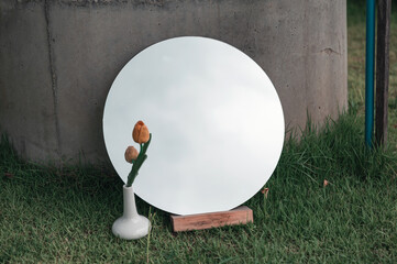 Canvas Print - Round mirror and yellow flower in white ceramic vase on lawn