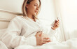 © kegfire - Happy pregnant woman with ultrasound scan resting in bedroom