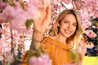 © New Africa - Young woman wearing stylish outfit near blossoming sakura in park. Fashionable spring look