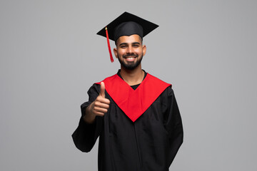 Wall Mural - Asian Graduate man in cap and gown smile Celebrating showing thumbs up with Confident emotional so proud and happiness in Graduation day isolated on white Background