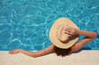© New Africa - Woman wearing hat in swimming pool, above view