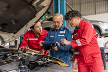 Senior Professional Mechanic Use An Obd2 Car Diagnostics Device Scanner To Interpreting Automotive Error Codes. Elderly Vehicle Mechanic Maintenance The Engine In Garage Workshop. Auto Repair Service
