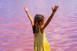 © sommersby - Happy little girl in yellow dress standing in water of pink salt lake on sunny summer day. Wanderlust travel concept