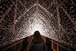 © Helene Helle - Girl walking over a fairy light bridge