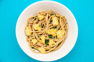 Wall Mural - Top view of chicken spaghetti on a bowl isolated on blue background