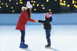 © New Africa - Mother and daughter spending time together at outdoor ice skating rink