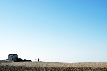 Poster - View of two people standing on the land with the house in the background on a sunny day