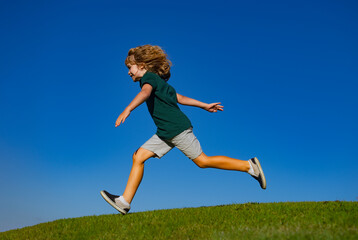 Little cute boy running on grass. Kids exploring nature, summer. Active healthy outdoor sport. Fun activity.