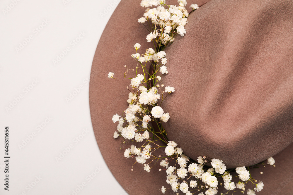 Beautiful gypsophila flowers and hat on light background