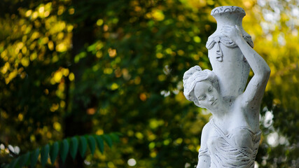 Canvas Print - sculpture of a girl in the spring park. An old statue in a park of a sensual semi-nude Greek or Italian Renaissance woman with a vase in a city park. sunny day in the summer garden. close-up