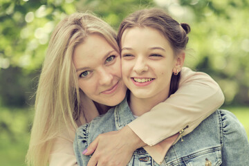 Wall Mural - happy mother with her daughter hugging a teenager in the summer. Caring happy mother enjoy day with teenage girl child, laugh have fun. Mother giving her daughter advice.