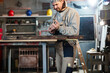 © astrosystem - Male carpenter working on old wood in a retro vintage workshop.