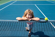 © Volodymyr - Child boy with tennis racket and ball on tennis court outdoor. Sport exercise for kids. Summer activities for children.