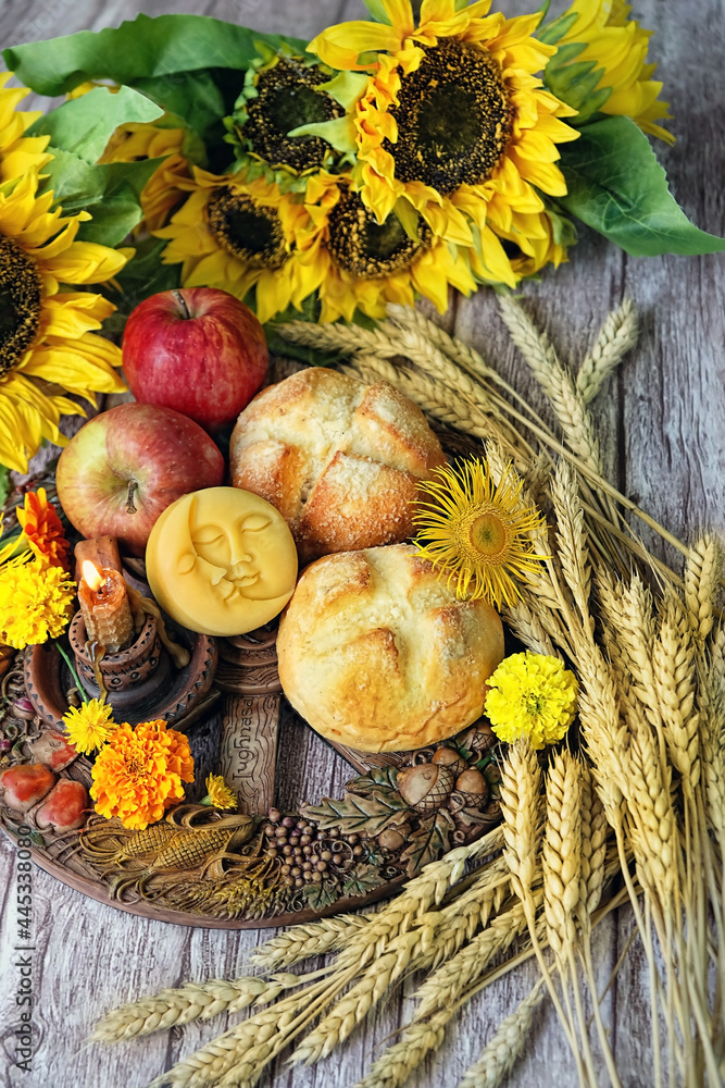 Wiccan Altar for Lammas, Lughnasadh pagan holiday. wheel of the year with ears of wheat, homemade bread, flowers, apple, candle on dark background. symbol of celtic wiccan sabbath, summer season - obrazy, fototapety, plakaty 