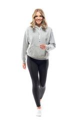 Happy young woman in gray sweatshirt and leggings walking towards camera. Full body isolated on white background.