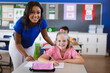 © WavebreakMediaMicro - African american female teacher and caucasian girl smiling in the class at elementary school