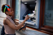 © JustLife - Beautiful african women using ATM machine. Attractive young woman withdrawing money from credit card at ATM...