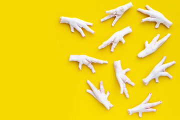 Wall Mural - Raw chicken feet on yellow background.