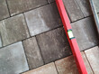 Laying paving stones. Measuring the slope with a spirit level. Laying paving stones on sand. A spirit level for measuring in construction concept