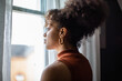 © ReeldealHD images - African american female looking out of window in home