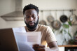 © ReeldealHD images - African American male looking at bills and paperwork