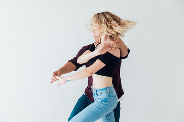 a man and a woman dance bachata music in a white room