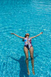 © Anton Tolmachov - Slim woman lies on a water surface in the clear pool