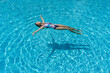 © Antonio - View of slim woman lies on a water surface in the crystal pool
