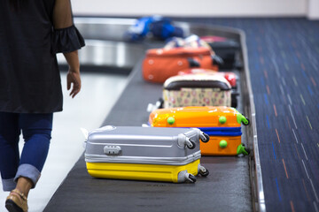 Poster - Wheeled suitcase, bags and backpacks on a luggage belt at the airport terminal.