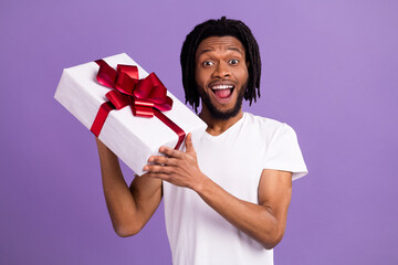 Wall Mural - Portrait of attractive cheerful guy holding giftbox event congrats isolated over bright violet purple color background