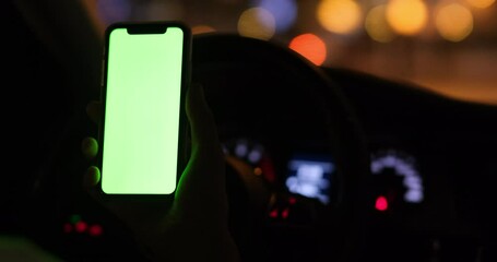 Wall Mural - hand holding green screen mobile phone in car at night. beautiful bokeh