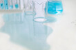 © LOUIS CHRISTIAN/Westend61 - Spilled liquid and glassware on table in laboratory