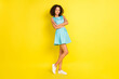© deagreez - Photo of shiny charming dark skin woman wear blue outfit glasses arms crossed smiling isolated yellow color background