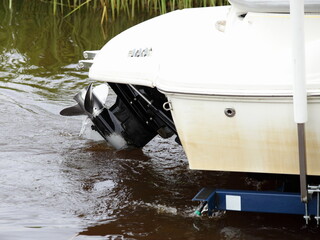 Wall Mural - Restrictive gate posts for parking a boat on a trailer on Transom with lower unit stern drive motor boat with inboard engine background in water on slipway at summer day, , watersrafts launching