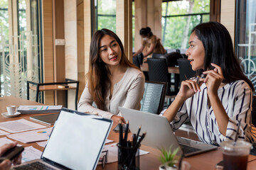 Wall Mural - Group of beautiful Asian businesswoman meeting suggest ideas brainstorm together using a laptop and documents at the office.