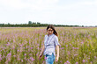 © Lena_viridis - Young beautiful smiling blond woman in purple shirt from behind walking in the meadow among flowers of fireweed, beauty in nature landscape