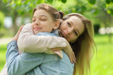 Wall Mural - happy mother with her daughter hugging a teenager in the summer. Caring happy mother enjoy day with teenage girl child, laugh have fun. Mother giving her daughter advice.