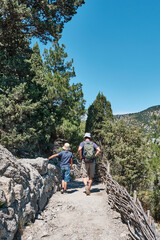 little boy and man hiking on scenic golitsyn trail, national botanical reserve new world, crimea
