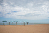 Fototapeta Morze - Beach umbrellas on sandy beach and sea background. Summer, travel, beach vacation concept.