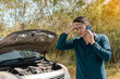© C_Production - Stressed man using phone for contact maintenance car service. Car broken concept.